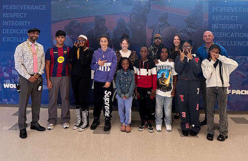 A Cause For The Cuse member joins students and staff of Brighton Academy for a photo