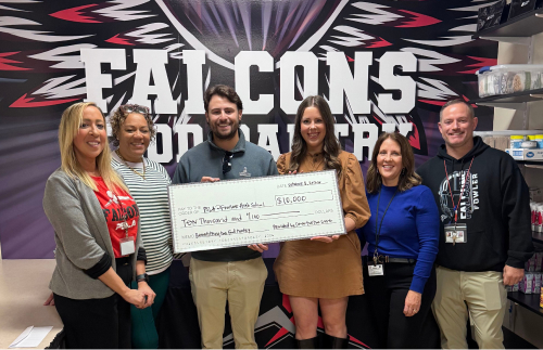 Members of Cause For The Cuse present a check to Corcoran High School leadership